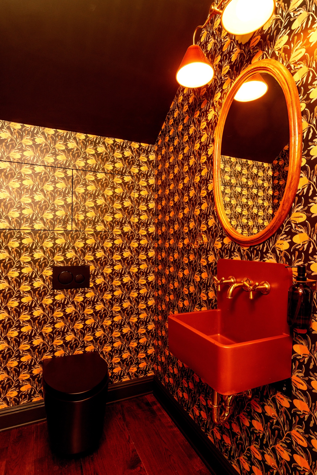 Powder room with floral wallcovering and red sink