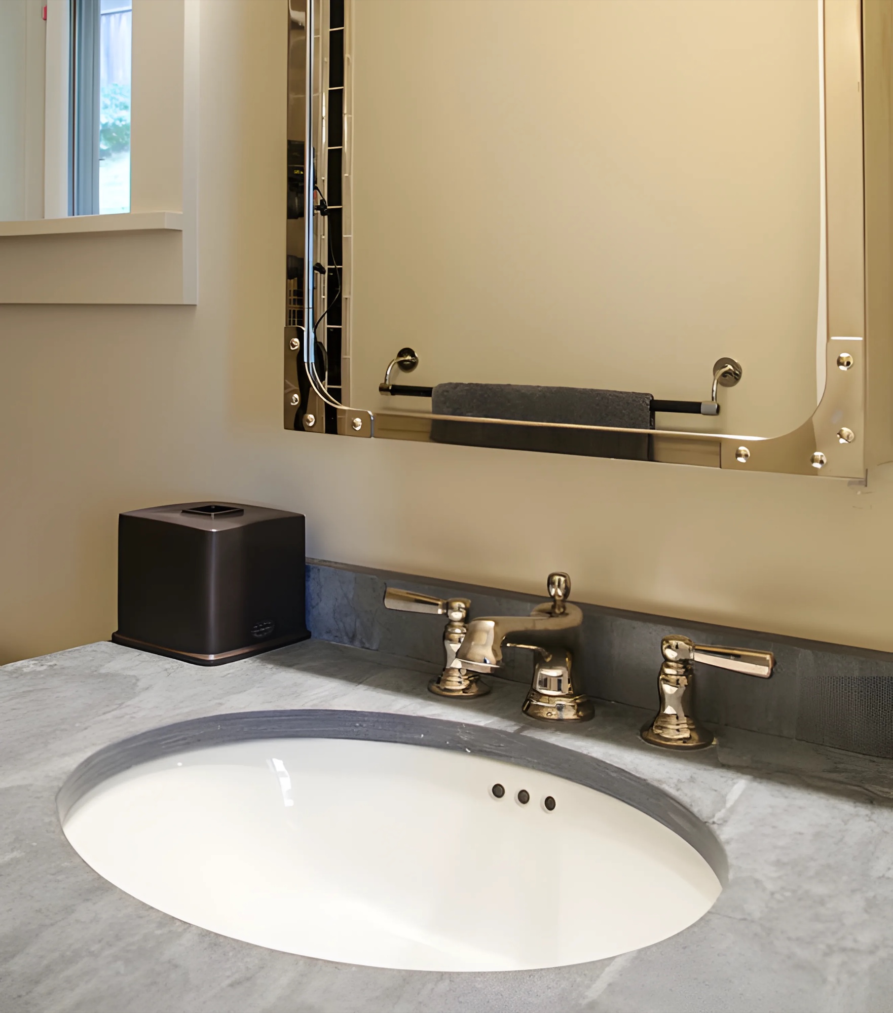 Oval bathroom sink with a marble counter and chrome-framed mirror by M2