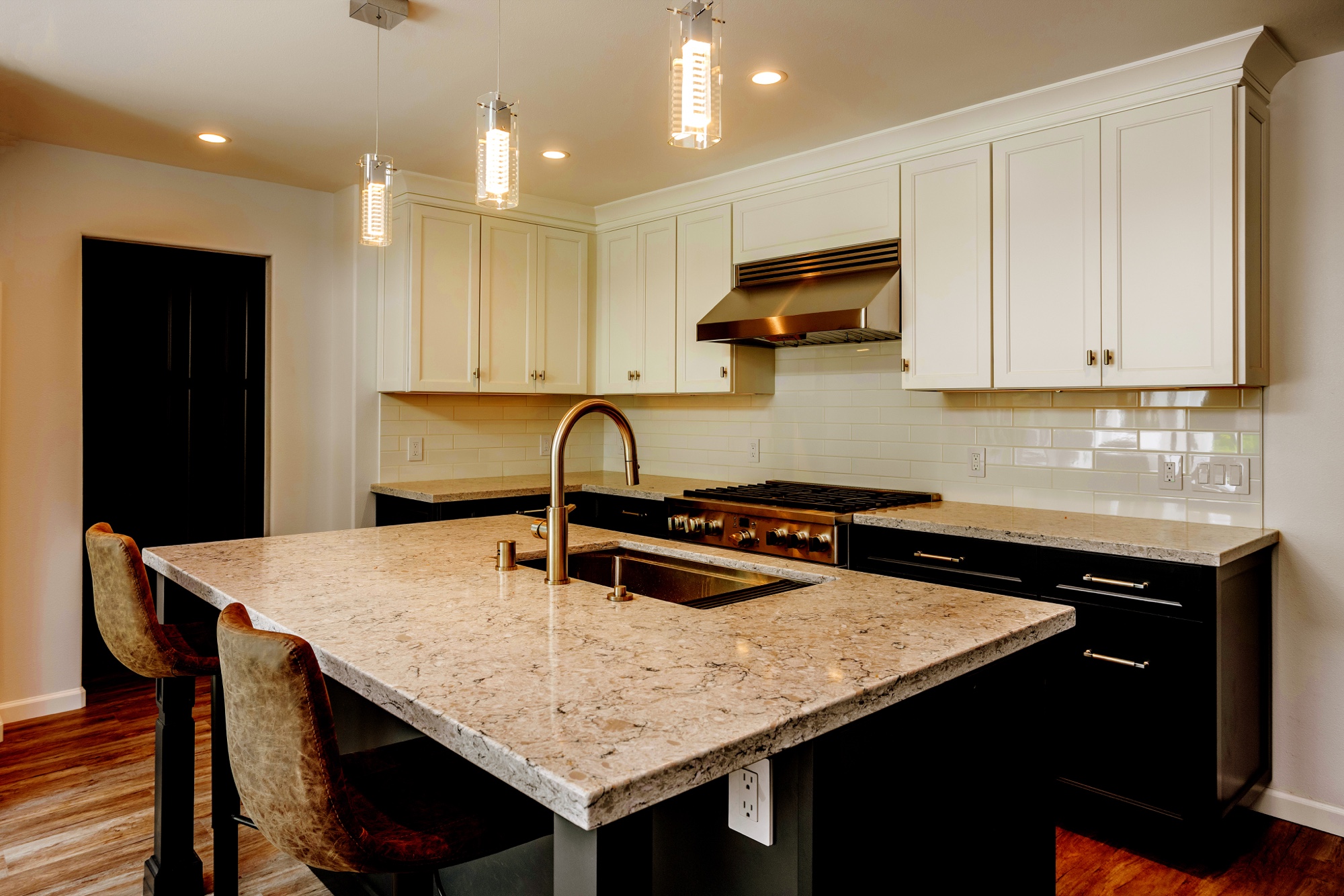 Kitchen island with stone counter and pendant lighting by M2