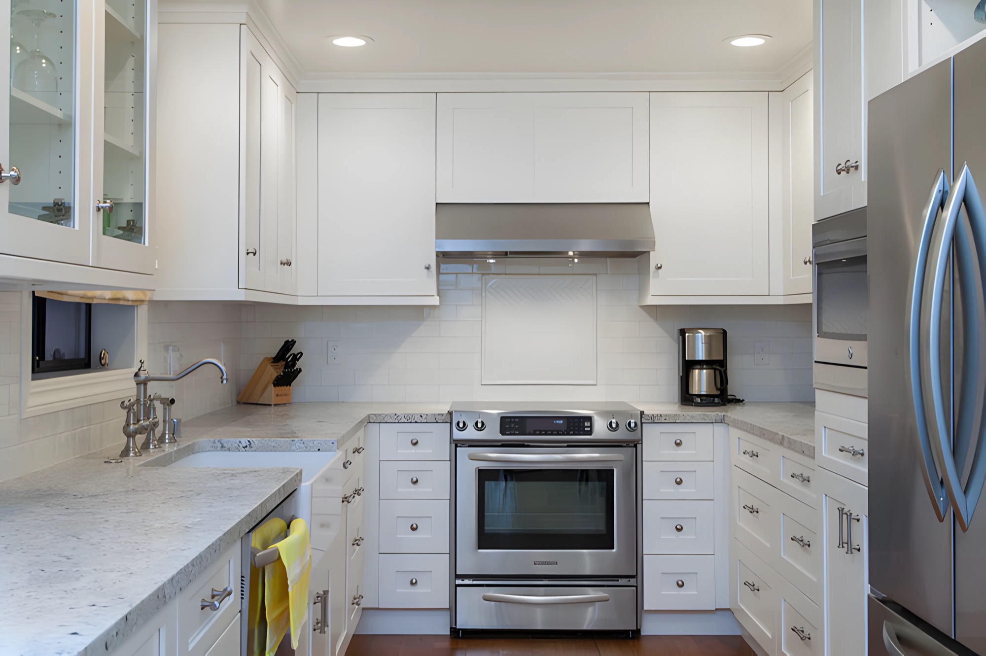 White galley kitchen remodel with marble counters by M2