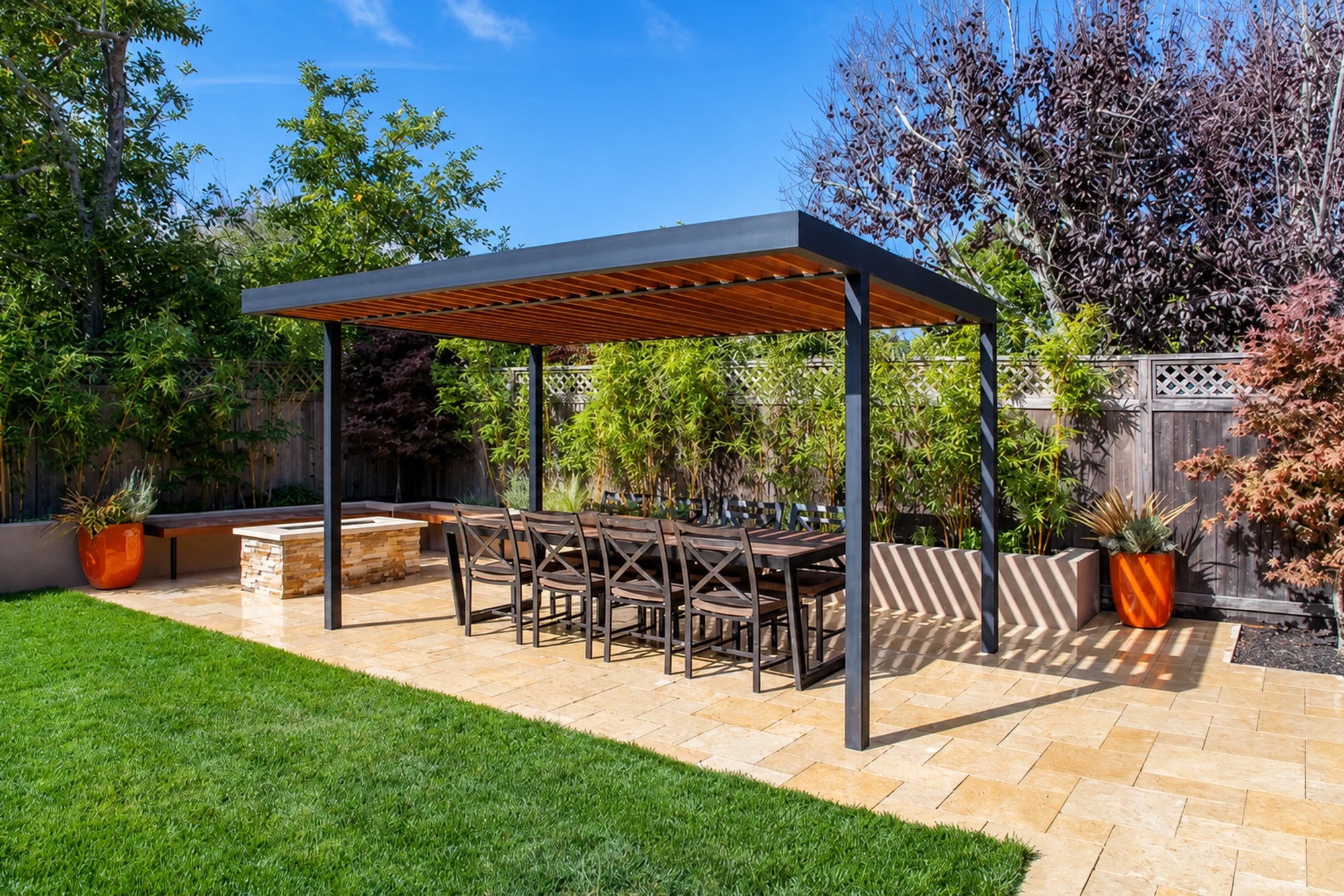 Outdoor dining terrace beneath a modern wood-slat pergola by M2